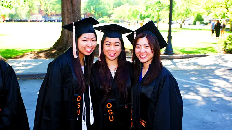 three graduates at commencement