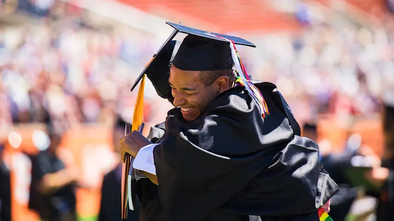 Two graduates embracing at commencement